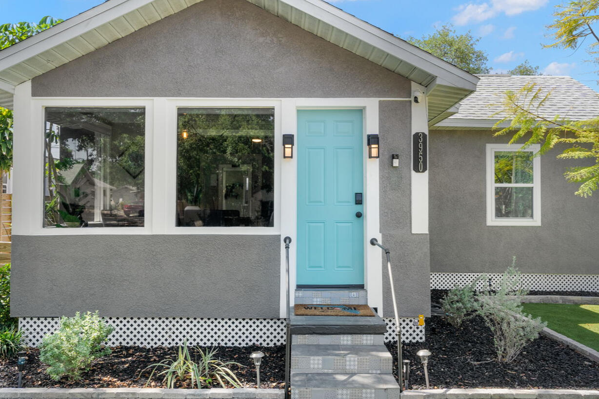 Front exterior of Jasper House with landscaped yard and turquoise entry door